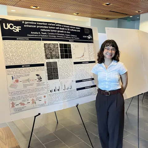 Scholar standing in front of poster