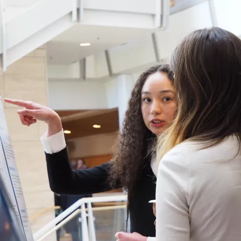 Scholar pointing to a science poster