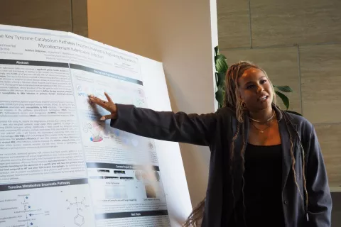 Scholar pointing to science poster